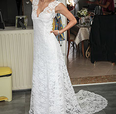 la mariée est face au photographe et allonge le bras avec sa robe