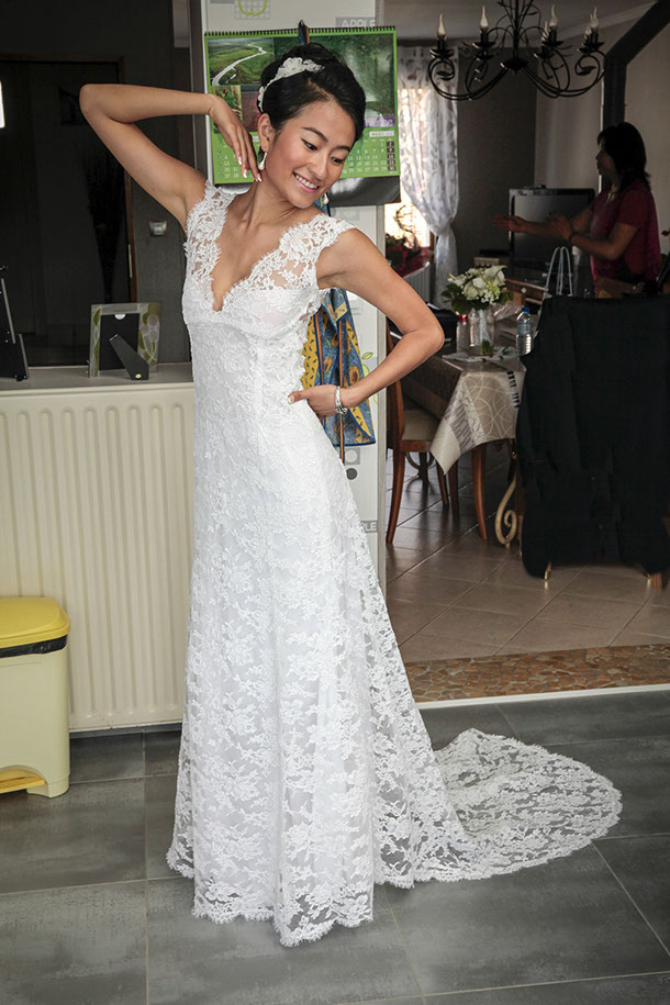 la mariée est face au photographe et allonge le bras avec sa robe