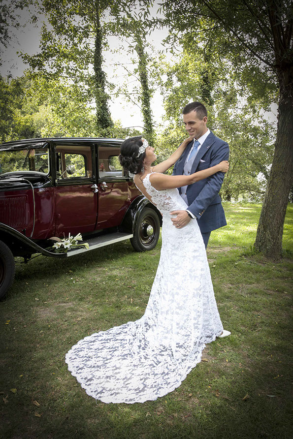 Krystal en déséquilibre arriere enlacée par son mari Aurélien devant une vieille voiture rouge au lac d'Ardres