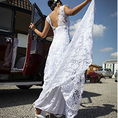 la mariée sort de son auto et prend sa robe en main