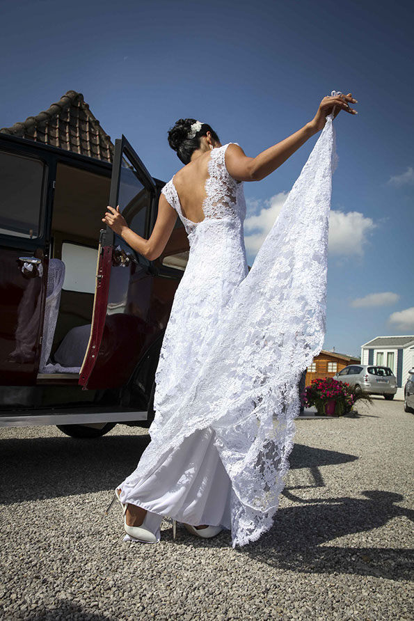 la mariée sort de son auto et prend sa robe en main
