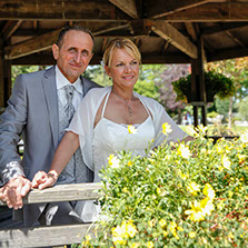 COUPLE FACE REGARDANT OBJECTIF AU BALCON D'UNE PERCOLA AVEC PLEIN DE BELLES FLEURS