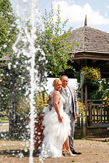 COUPLE DE 3/4 DEVANT UN JET D'EAU ET PERGOLA AU JARDIN PUBLIQUE DE GRANDE SYNTHE