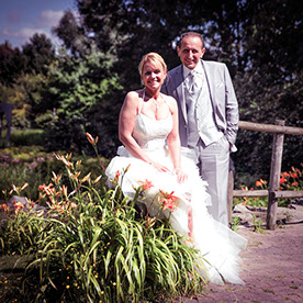 PHOTO CARREE AVEC COUPLE LA MARIEE EST ASSISE ET LE MARIE EST DEBOUT A DROITE