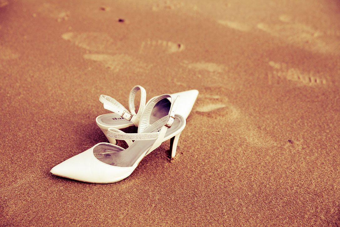 PAIRE DE CHAUSSURES POSEE SUR LA PLAGE LORS DE LA PRISE DE VUE