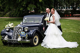 COUPLE DE MARIES POSES DEVANT UNE TRACTION NOIRE DANS LE PARC PRES DE LA CITADELLE