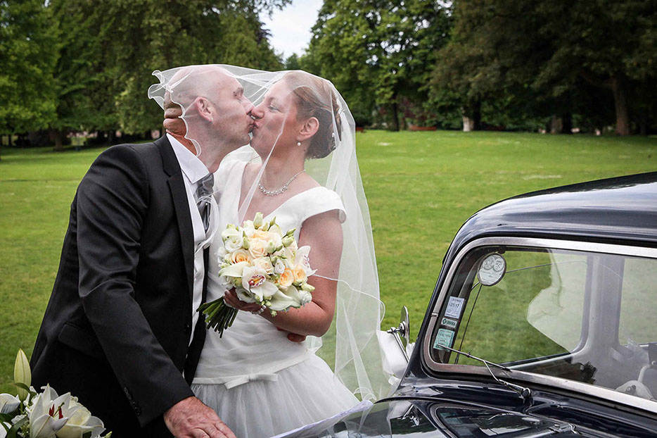 COUPLE DE MARIES POSES DEVANT UNE TRACTION NOIRE DANS LE PARC PRES DE LA CITADELLE EN PLAN RAPPROCHE